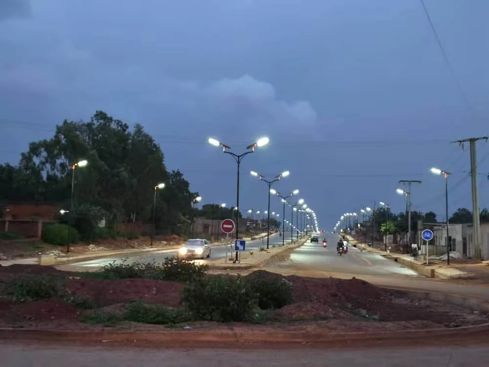 All-in-one solar street lights on a boulevard in Burkina Faso lighting up at dusk