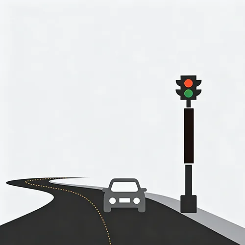 A gray car drives along a curved dark road next to a pole-mounted traffic light with red and green lights.